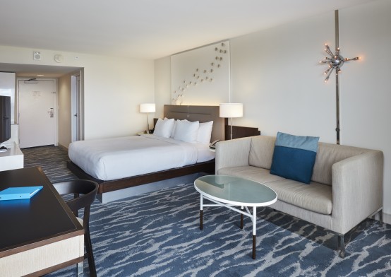 Room with King bed and small living area with couch and coffee table and desk